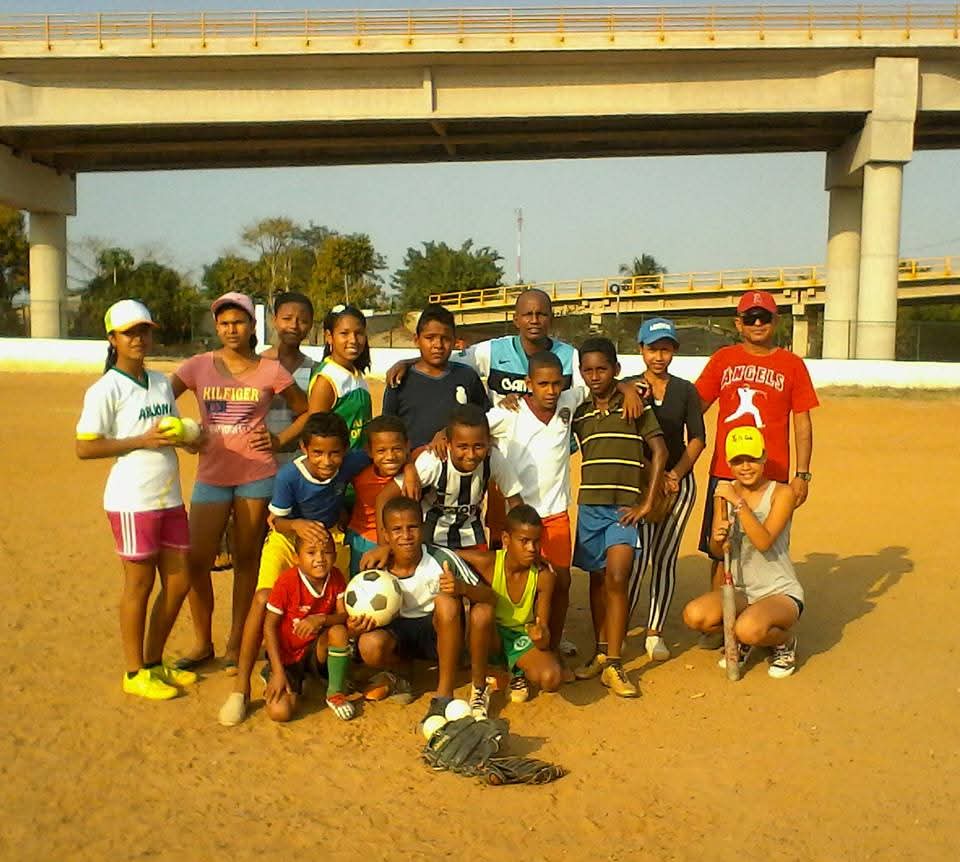 Niños y jóvenes practicando futbol y beisbol en el campo de Gambote